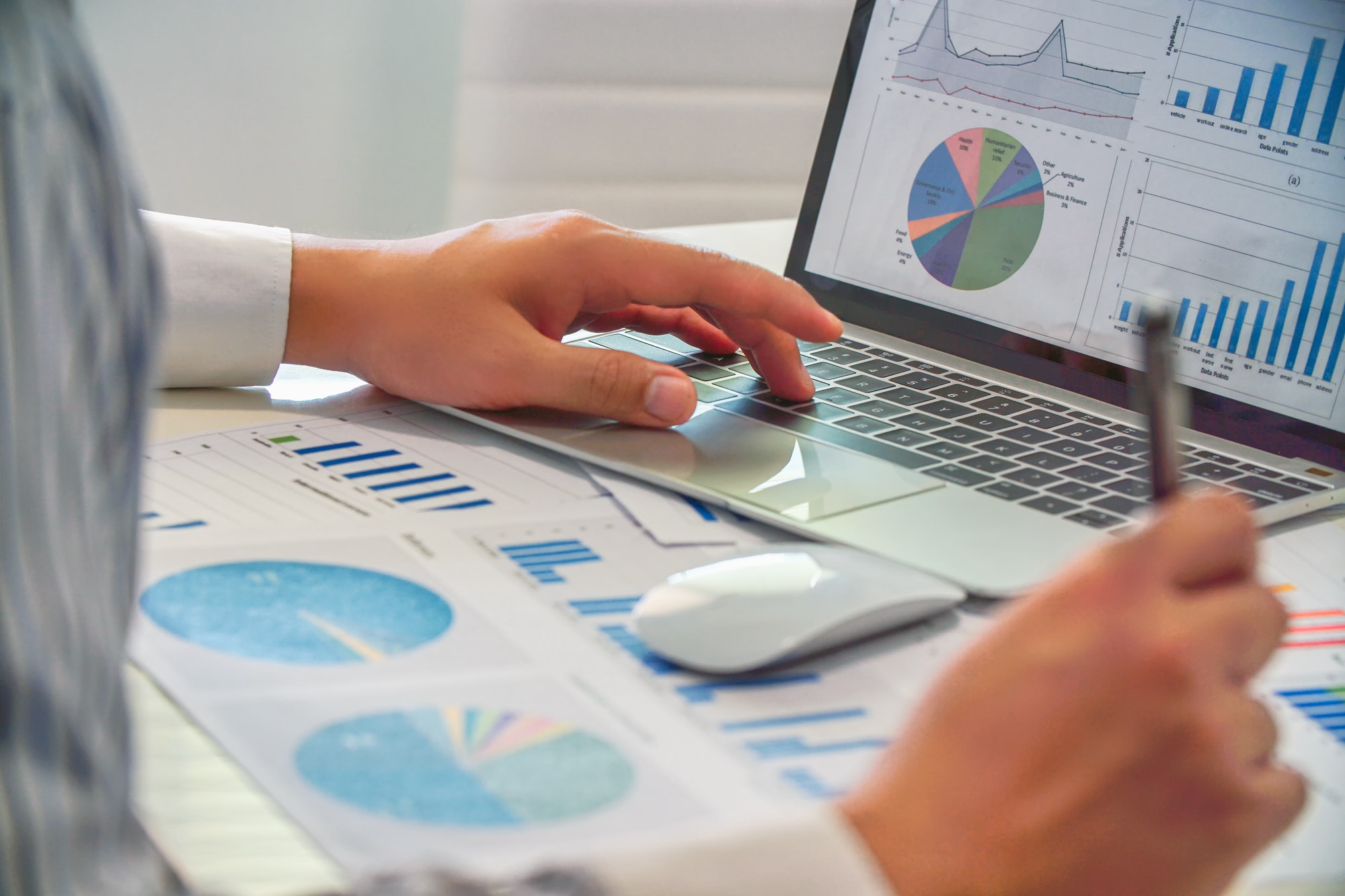 close up of business people analysis charts and graphs of marketing on laptop and paperwork